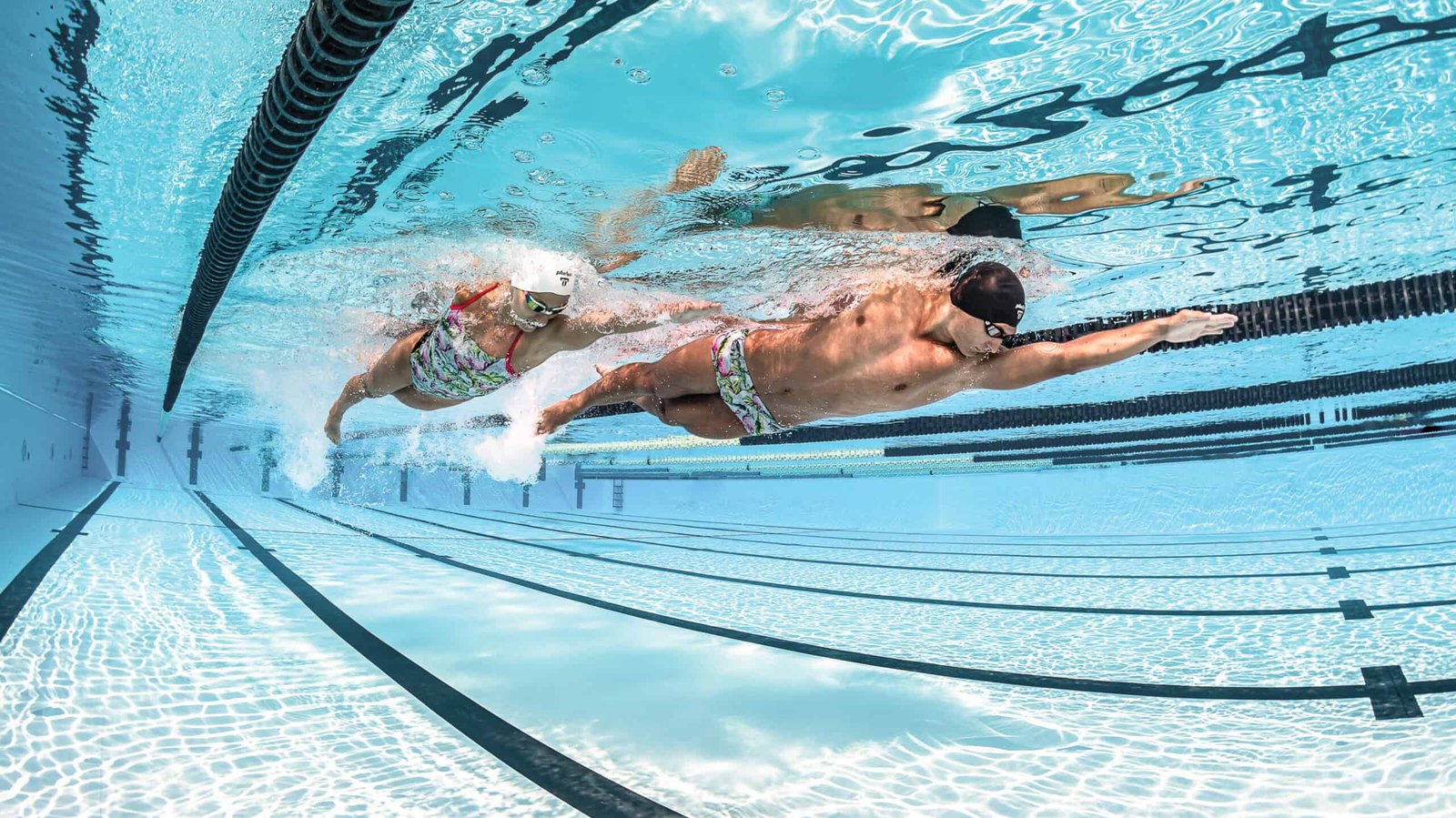 Swimmer's outstretched arm entering the water at the start of a freestyle stroke