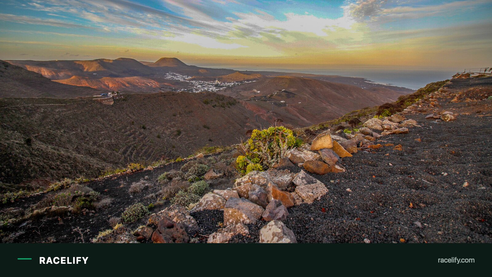 Triathletes cycling along a volcanic, windswept coastal road on Lanzarote.