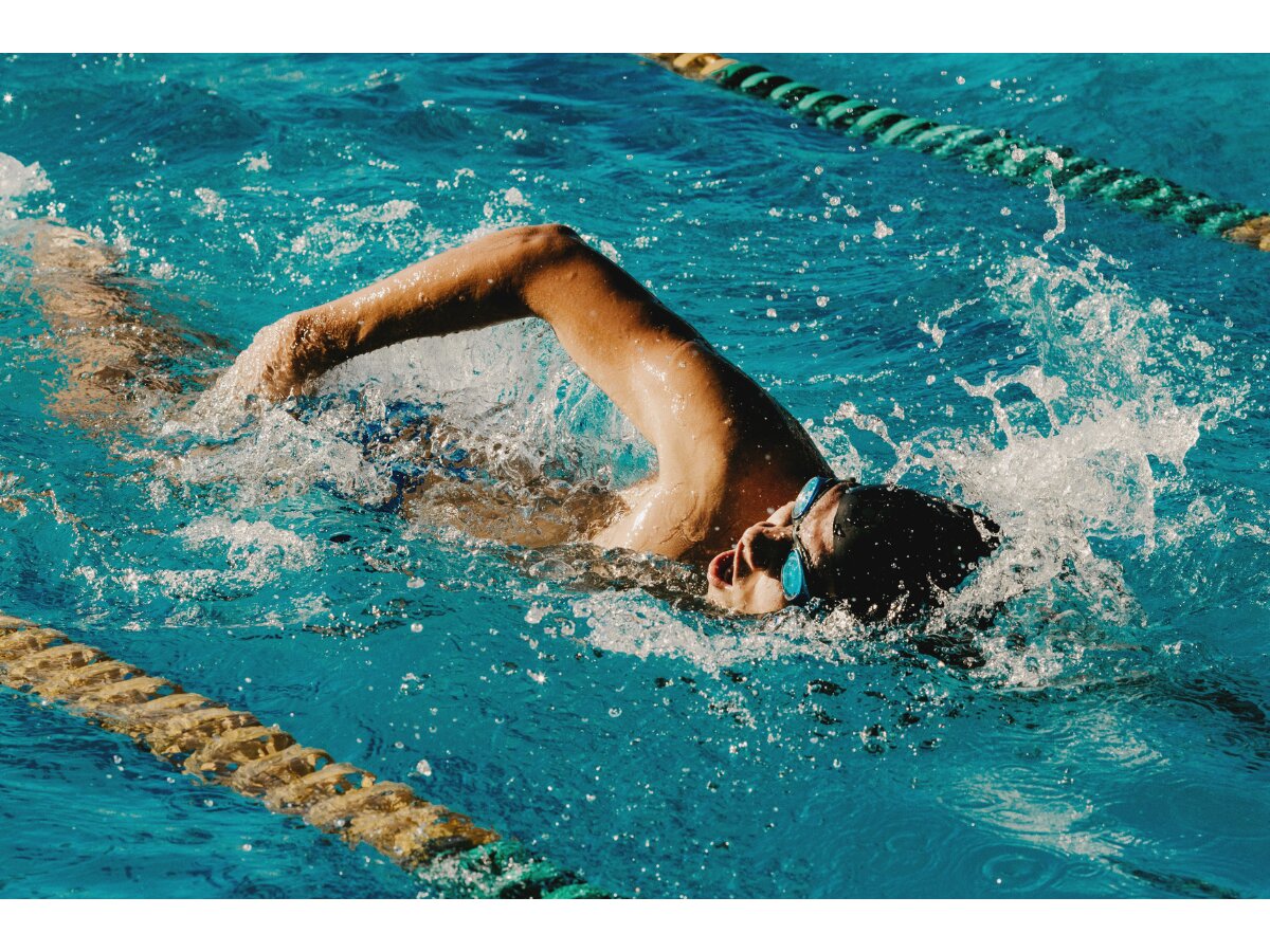 Swimmer training front crawl in a marked pool lane