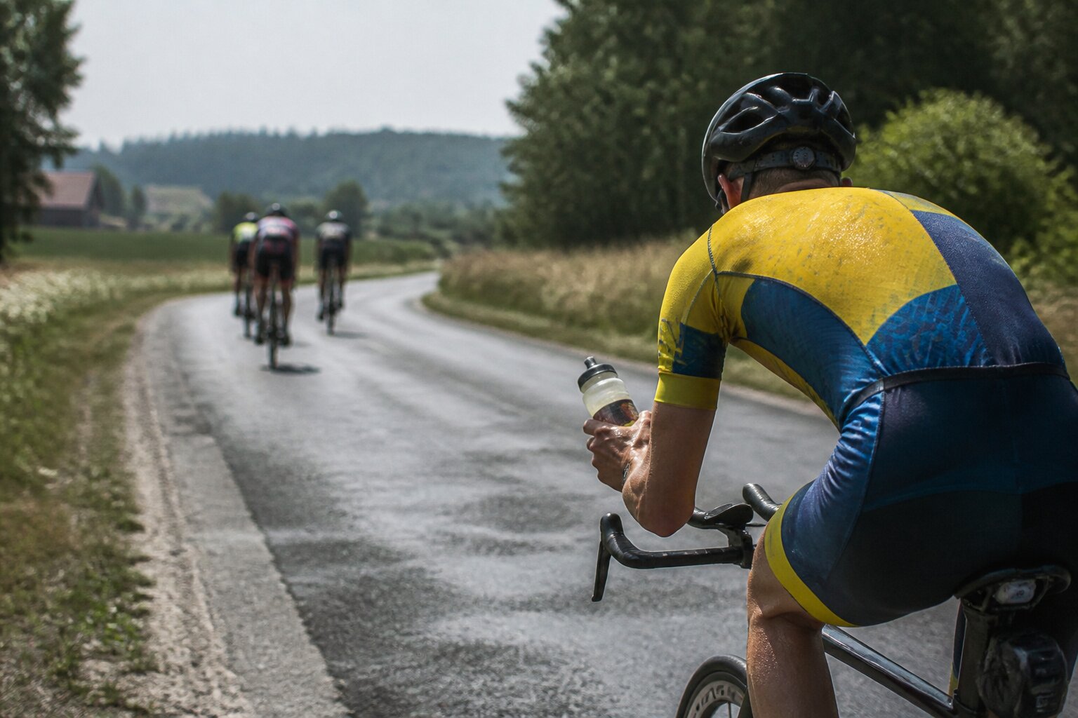 Cyclist drinking from a bottle during a hot-weather ride